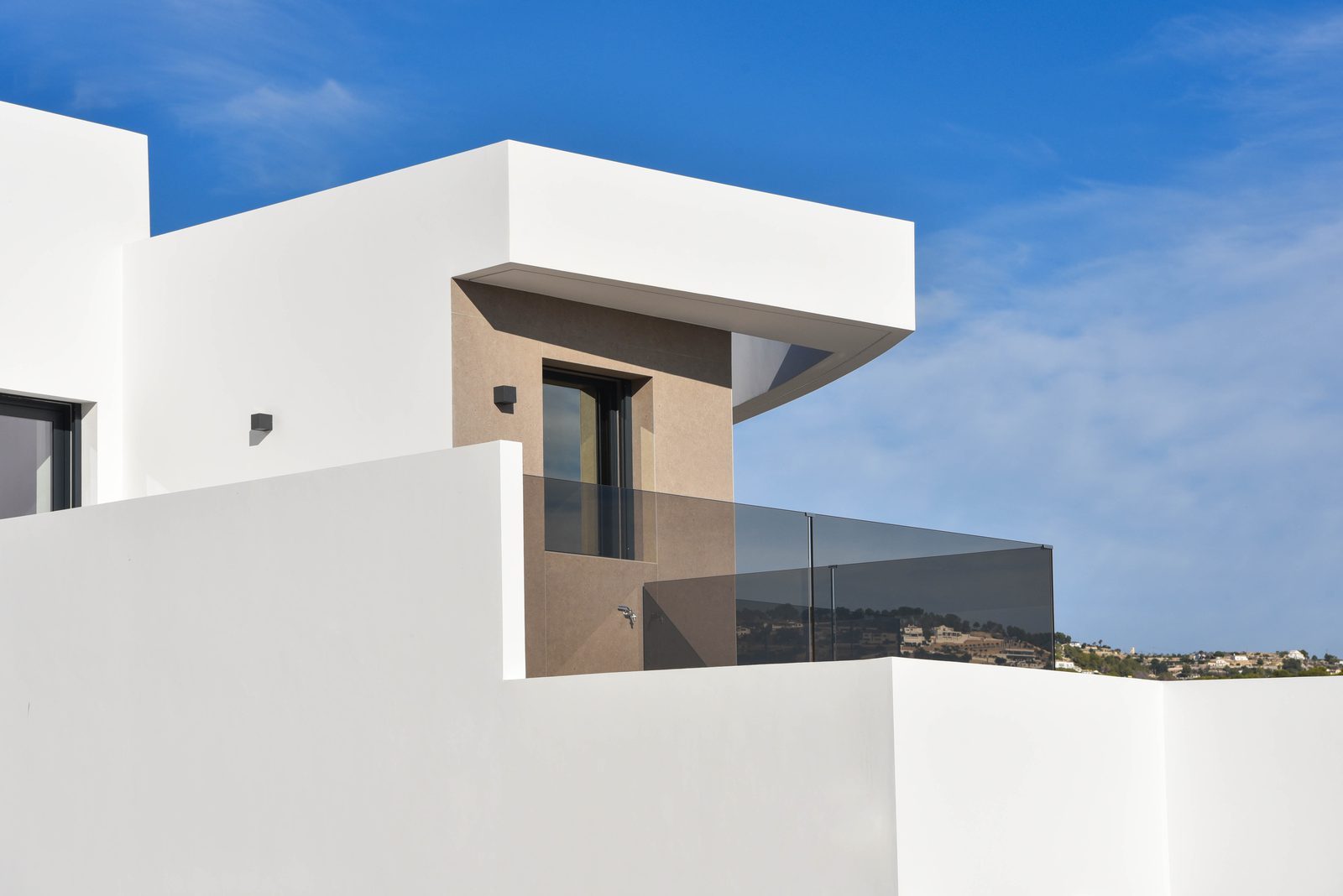 Modern white villa exterior with glass balcony and hillside views in La Fustera, Benissa - The Estates