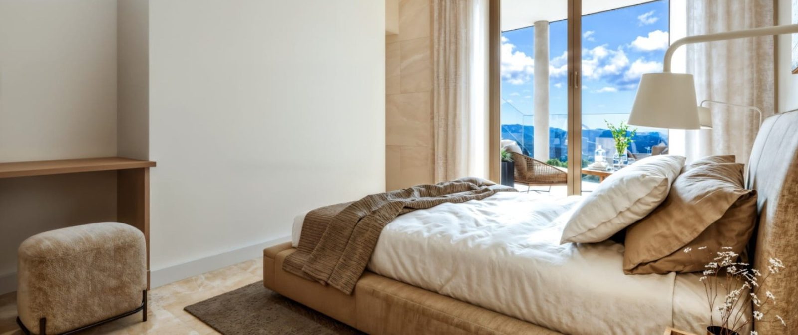 Bright bedroom with double bed, armchair, desk and balcony views of the sea and mountains in a 2-bedroom apartment in Calvia - The Estates