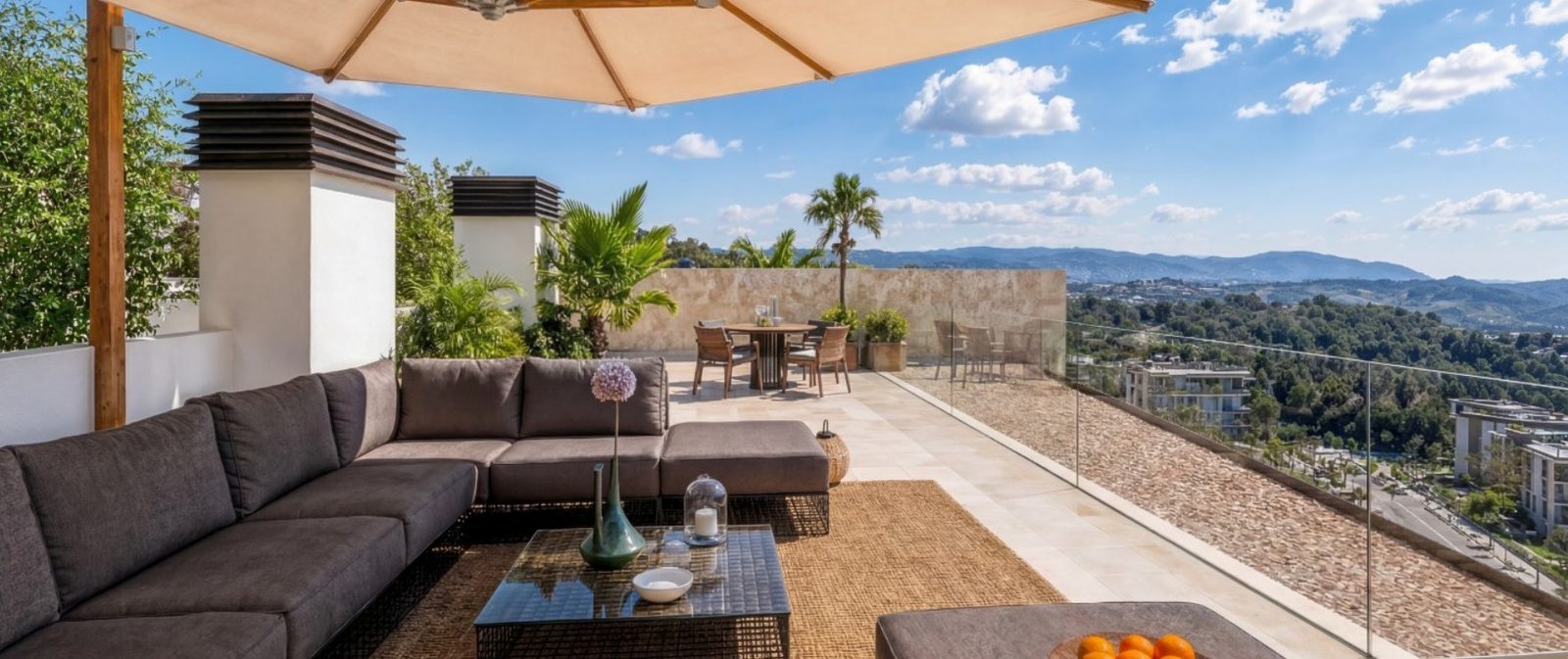 Rooftop terrace with lounge and dining area overlooking mountains at