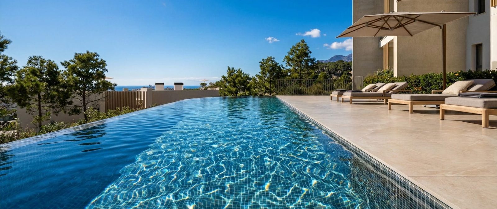 Infinity pool with sun loungers, sea and mountain views at a 2-bedroom apartment in Calvia - The Estates