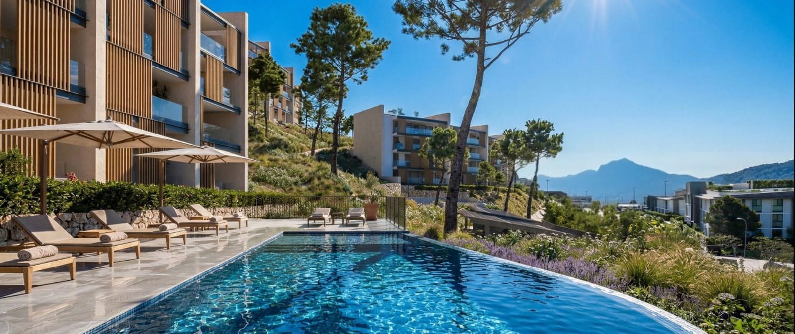 Outdoor pool with loungers and mountain views at
