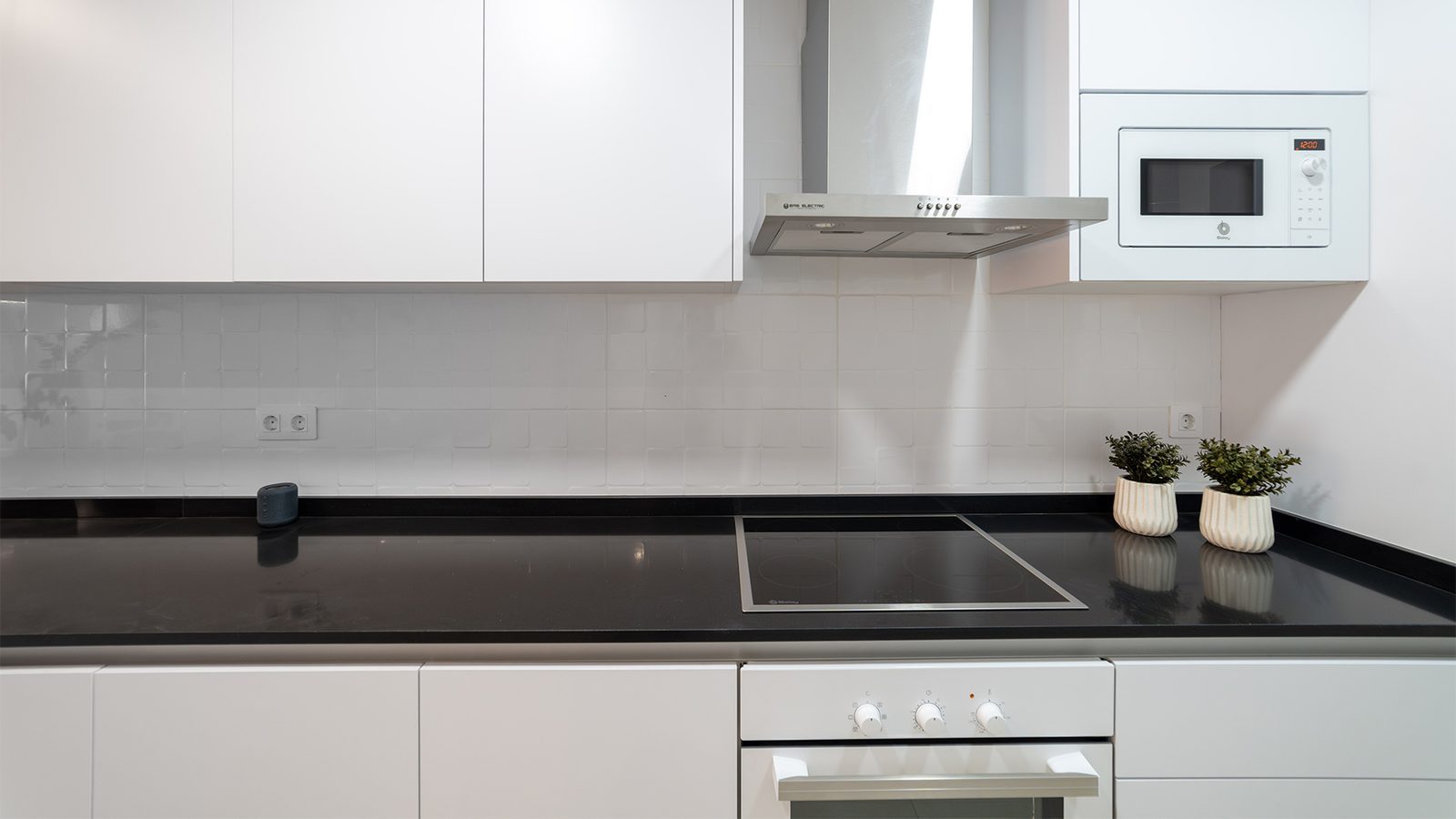 Modern fitted kitchen with black worktops, induction hob and integrated appliances in a 3-bedroom bungalow in Pulpí - The Estates