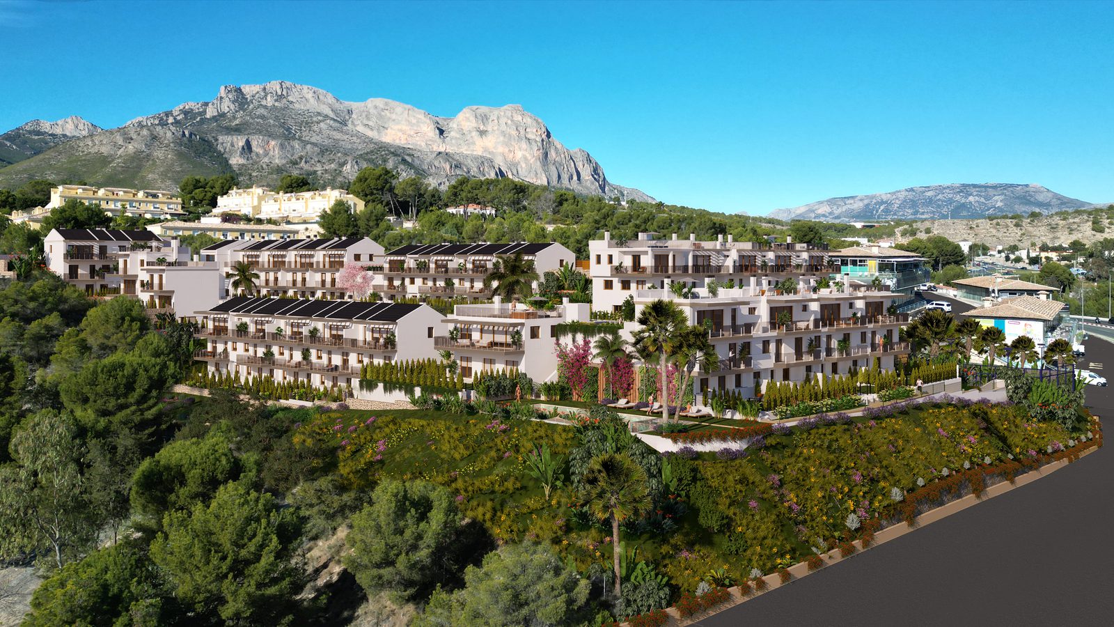 A view of a 4-bedroom townhouse complex nestled amongst lush greenery and mountains in La Nucía - The Estates