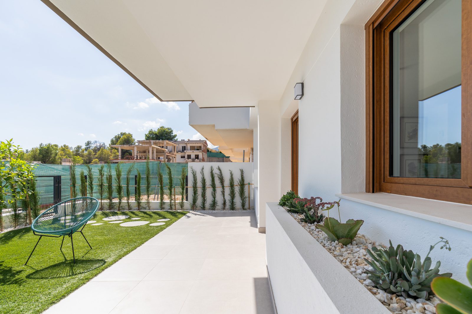 A modern terrace with seating and greenery at a 4-bedroom townhouse in La Nucía - The Estates