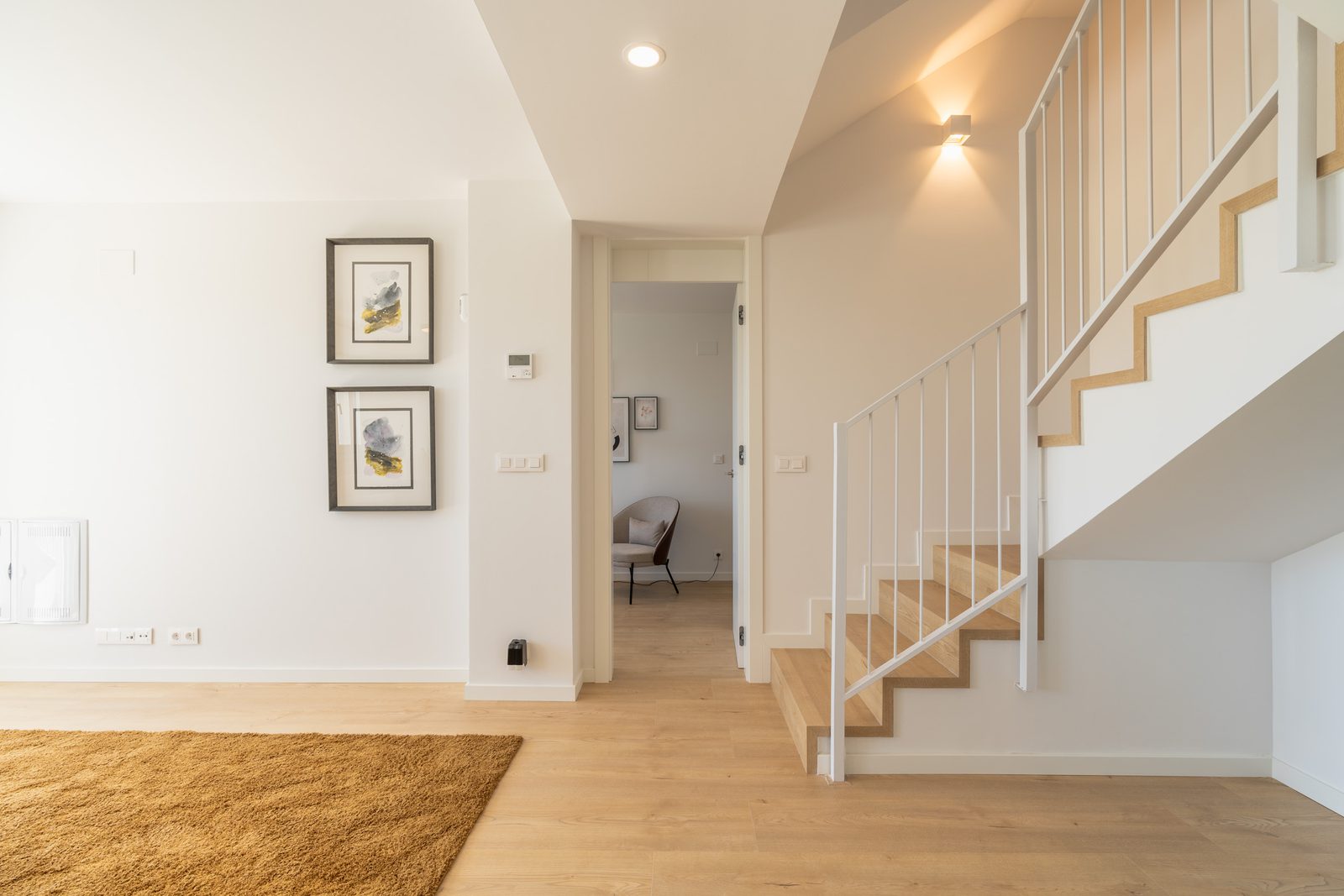 A bright hallway with a staircase and artwork in a 4-bedroom townhouse in La Nucía - The Estates