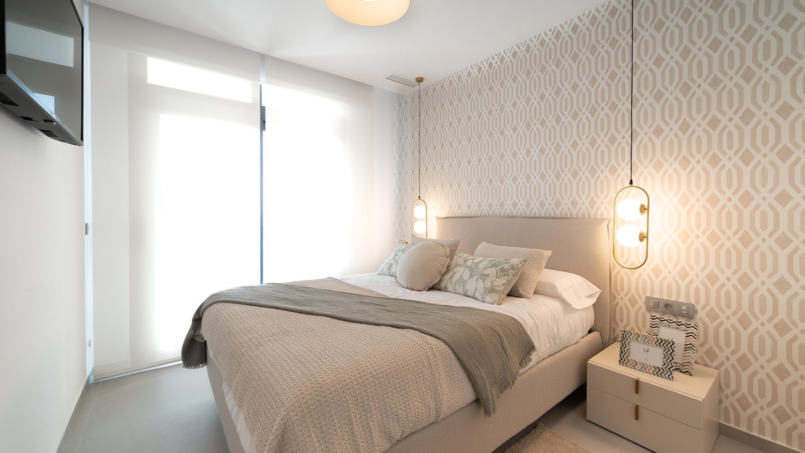 Stylish double bedroom with patterned feature wall, upholstered bed and pendant lights in a 3-bedroom penthouse in Benidorm - The Estates