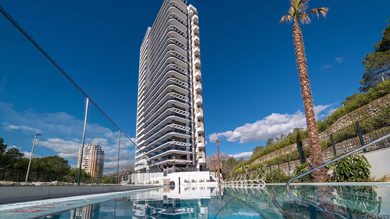 Modern high-rise apartment building and swimming pool exterior of a 3-bedroom penthouse in Benidorm —