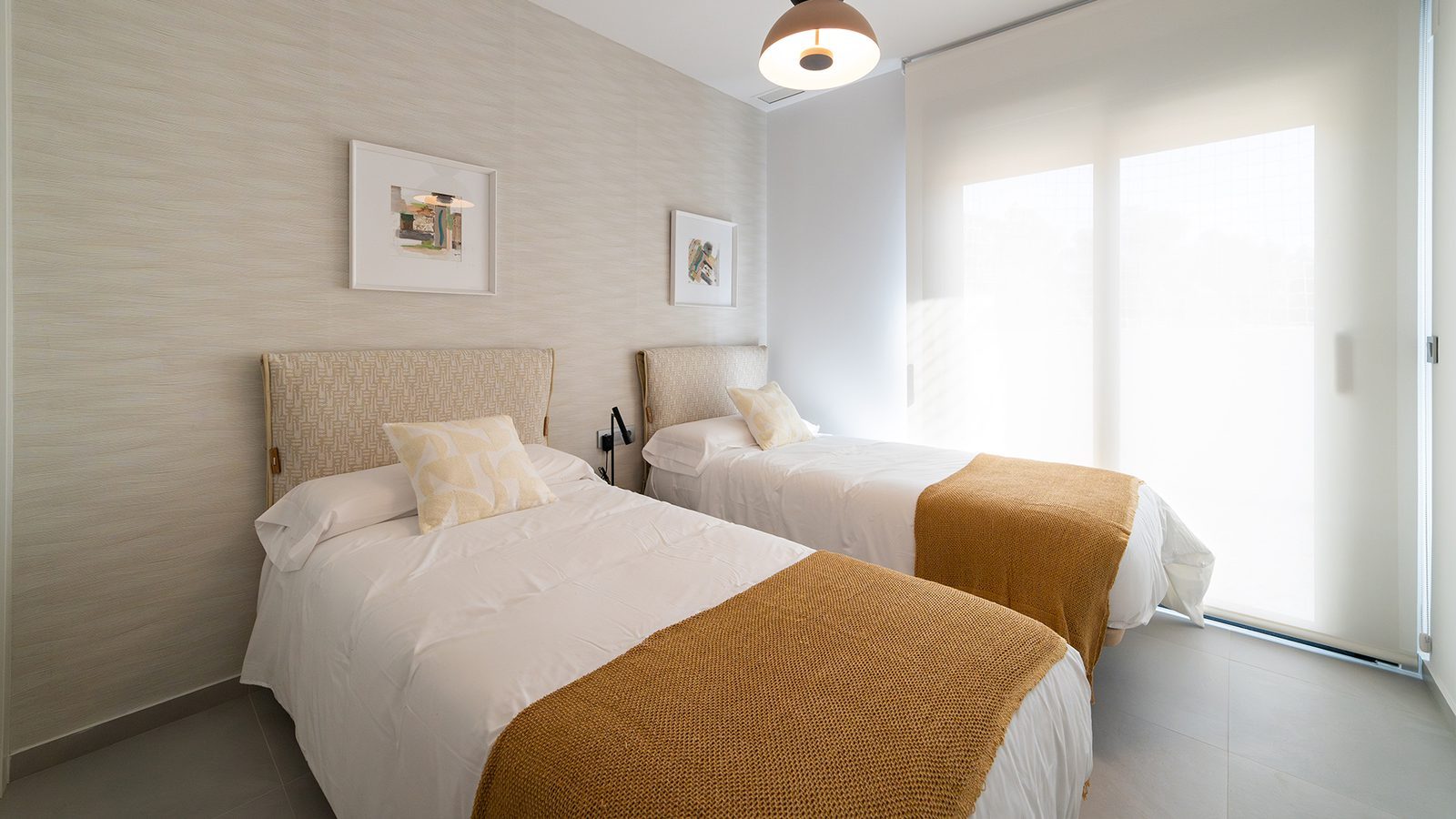 Twin bedroom with patterned headboards, white linens and mustard throws in a 3-bedroom penthouse in Benidorm - The Estates