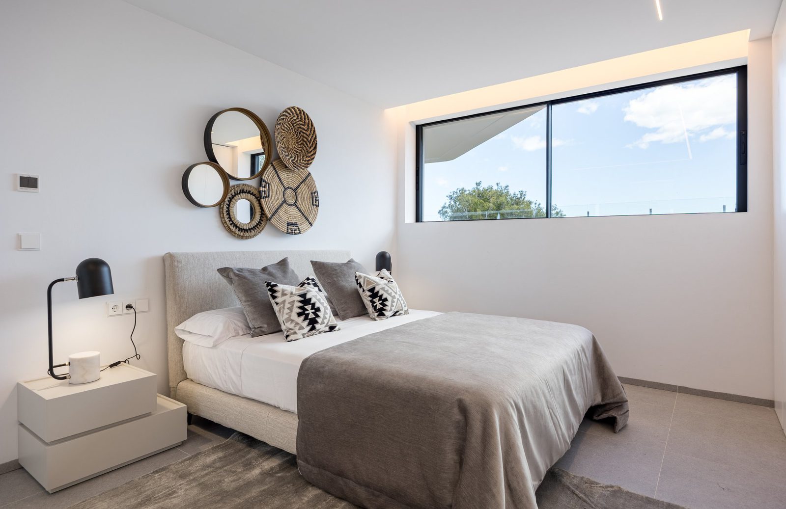 Stylish bedroom interior with large window and sea view in a 5-bedroom villa in Portixol - The Estates