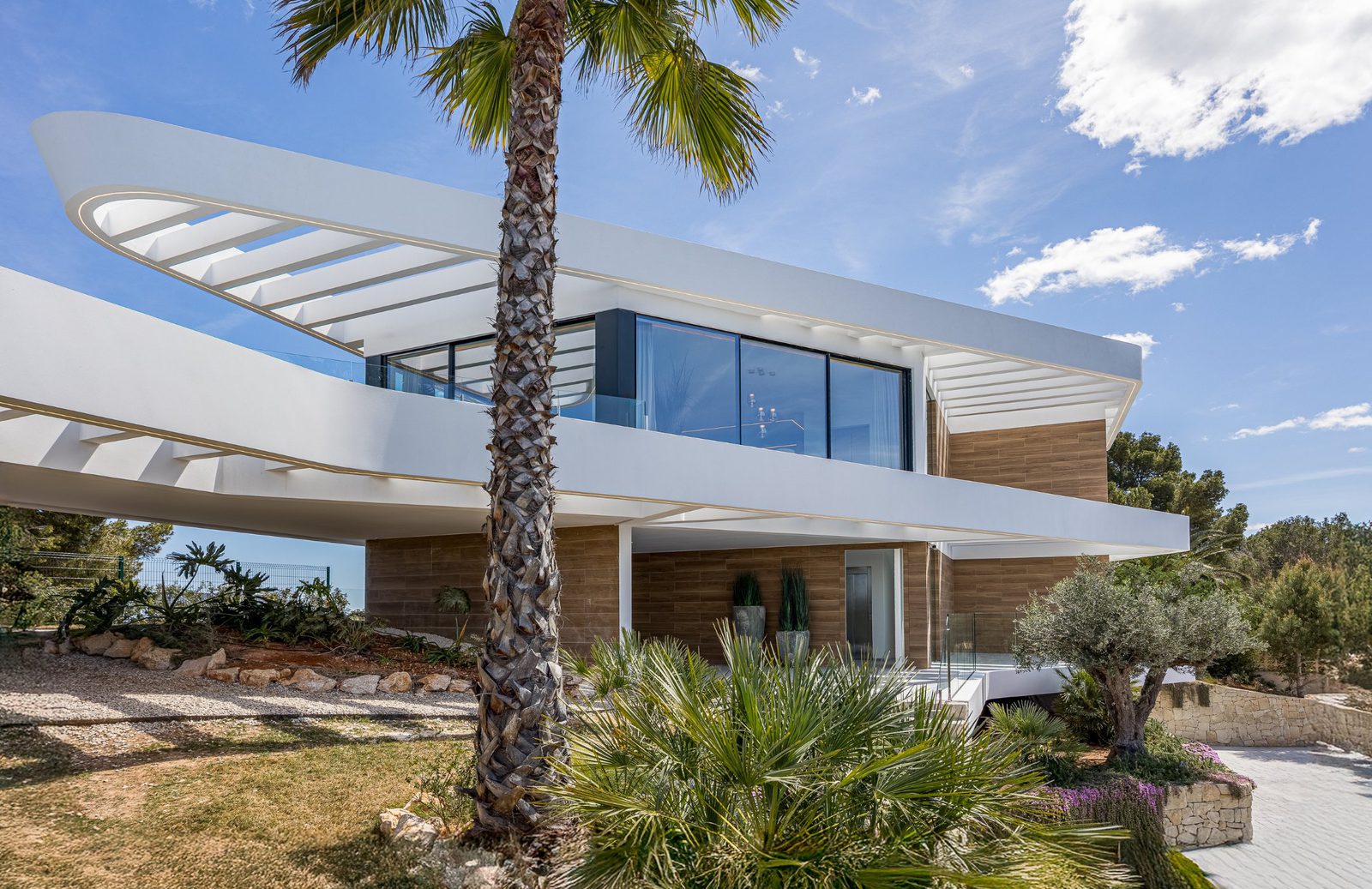 Modern architecture and lush greenery surround a 5-bedroom villa in Portixol - The Estates