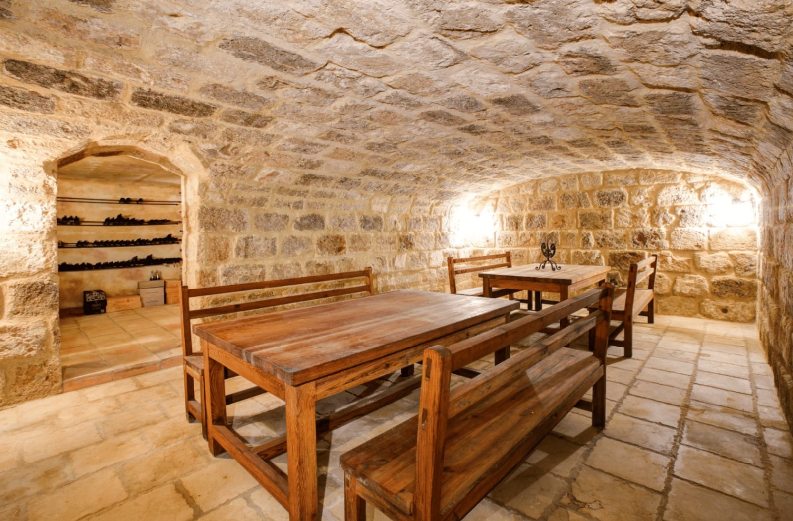 A rustic stone cellar with wooden tables and benches in a 4-bedroom finca in Moraira - The Estates