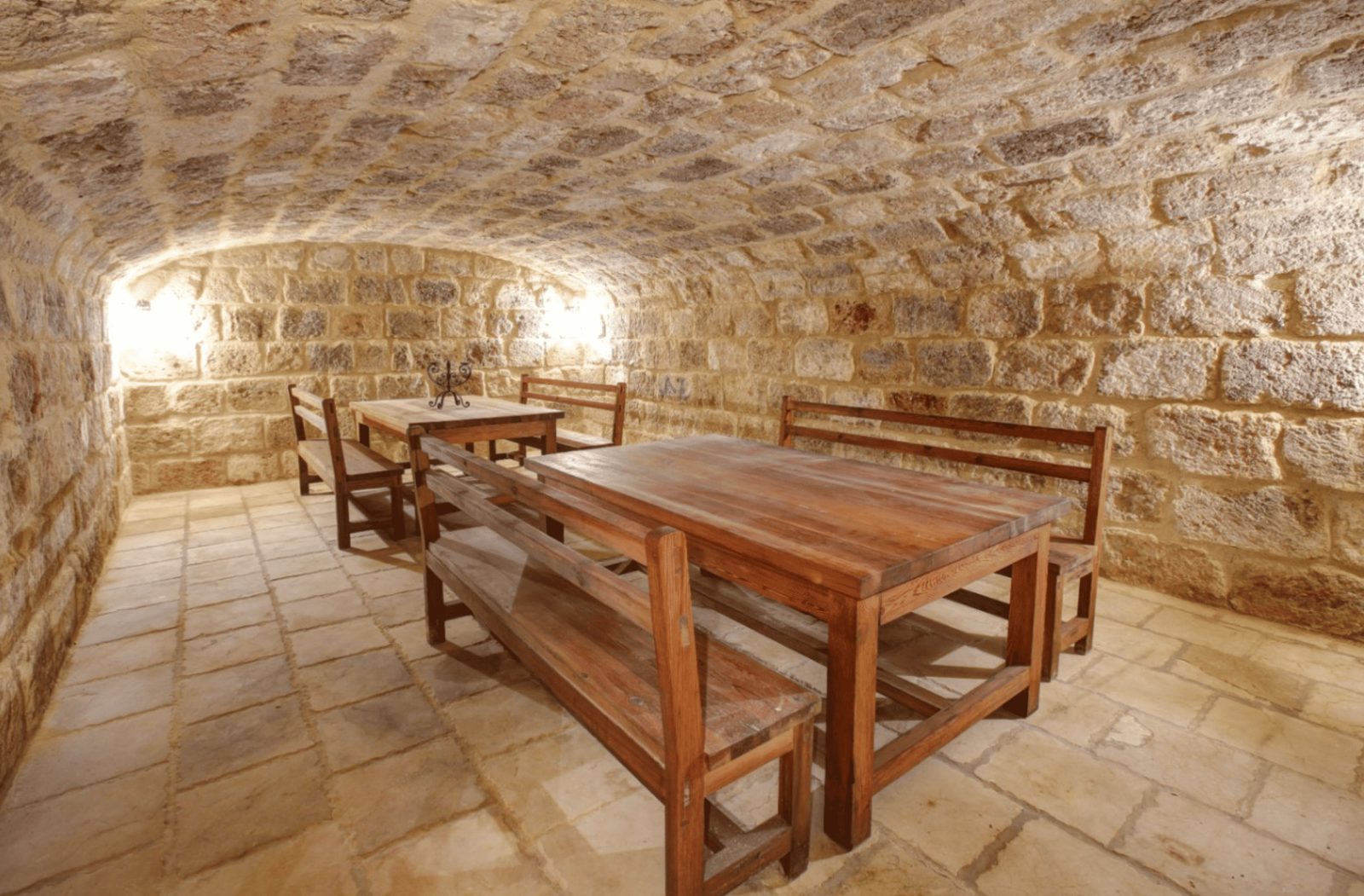 A rustic stone cellar with wooden table and benches inside a 4-bedroom finca in Moraira - The Estates