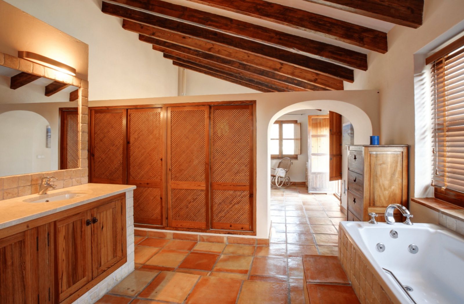 Stylish bathroom with wooden beams, built-in wardrobes, and a jacuzzi tub in a 4-bedroom finca in Moraira - The Estates
