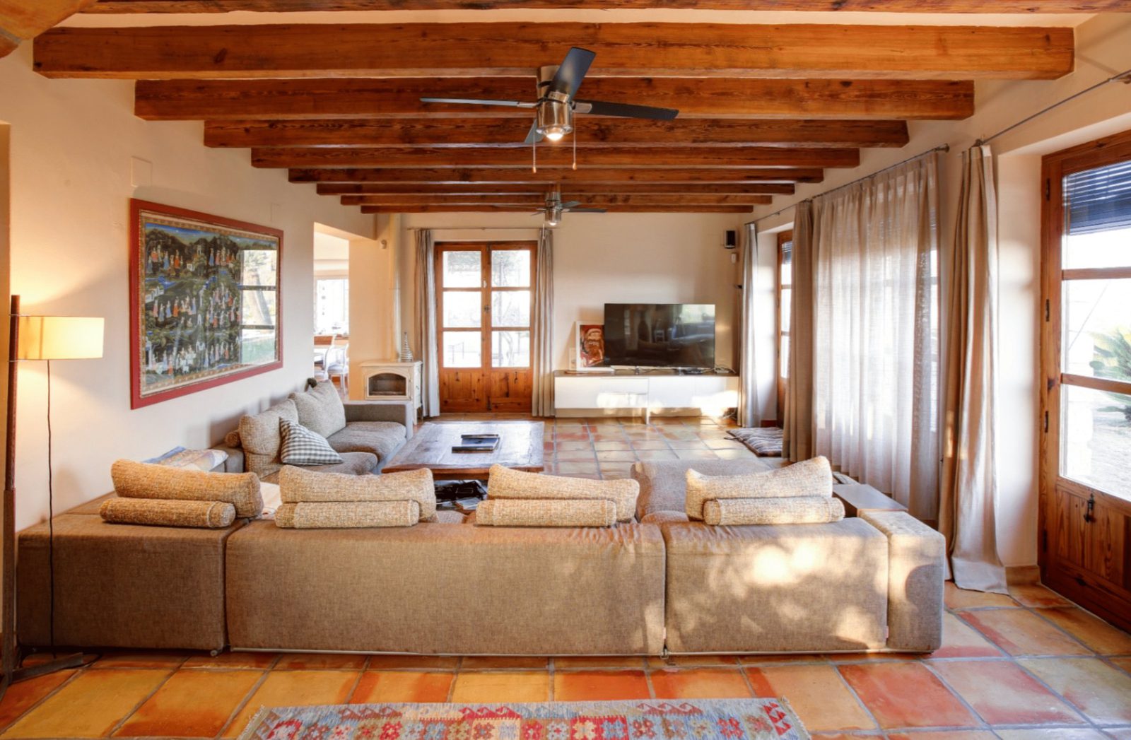 Stylish living room with exposed beams and tiled floors in a 4-bedroom finca in Moraira - The Estates