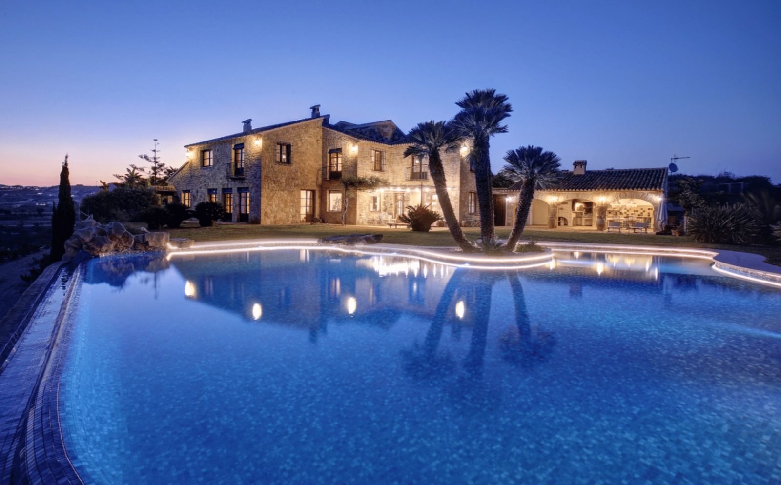 A stunning finca with a pool and countryside views at dusk in Moraira - The Estates