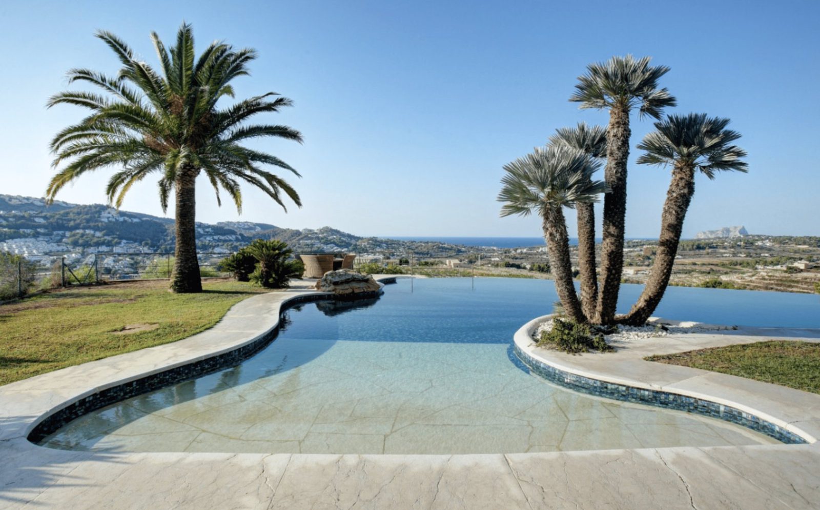 A stunning infinity pool and palm trees with sea and countryside views of a 4-bedroom finca in Moraira - The Estates