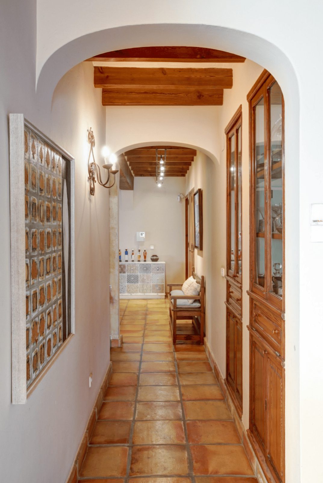An interior hallway with tiled floors and wooden details in a 4-bedroom finca in Moraira - The Estates
