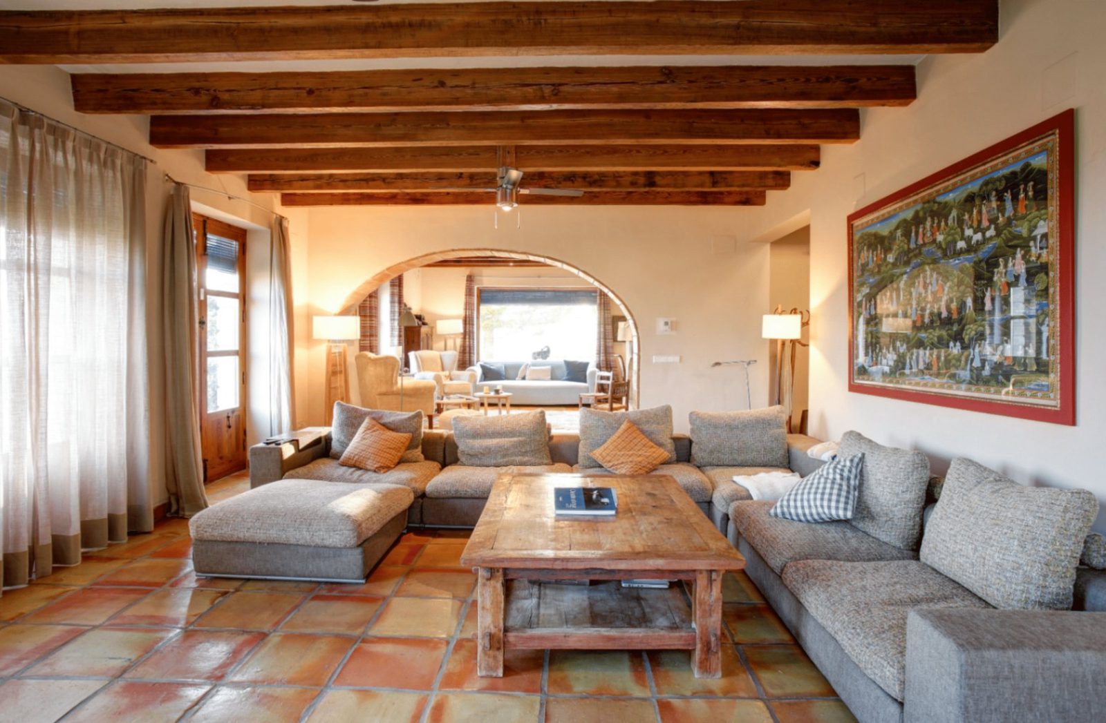 Stylish living room with exposed beams and terracotta floors in a 4-bedroom finca in Moraira - The Estates