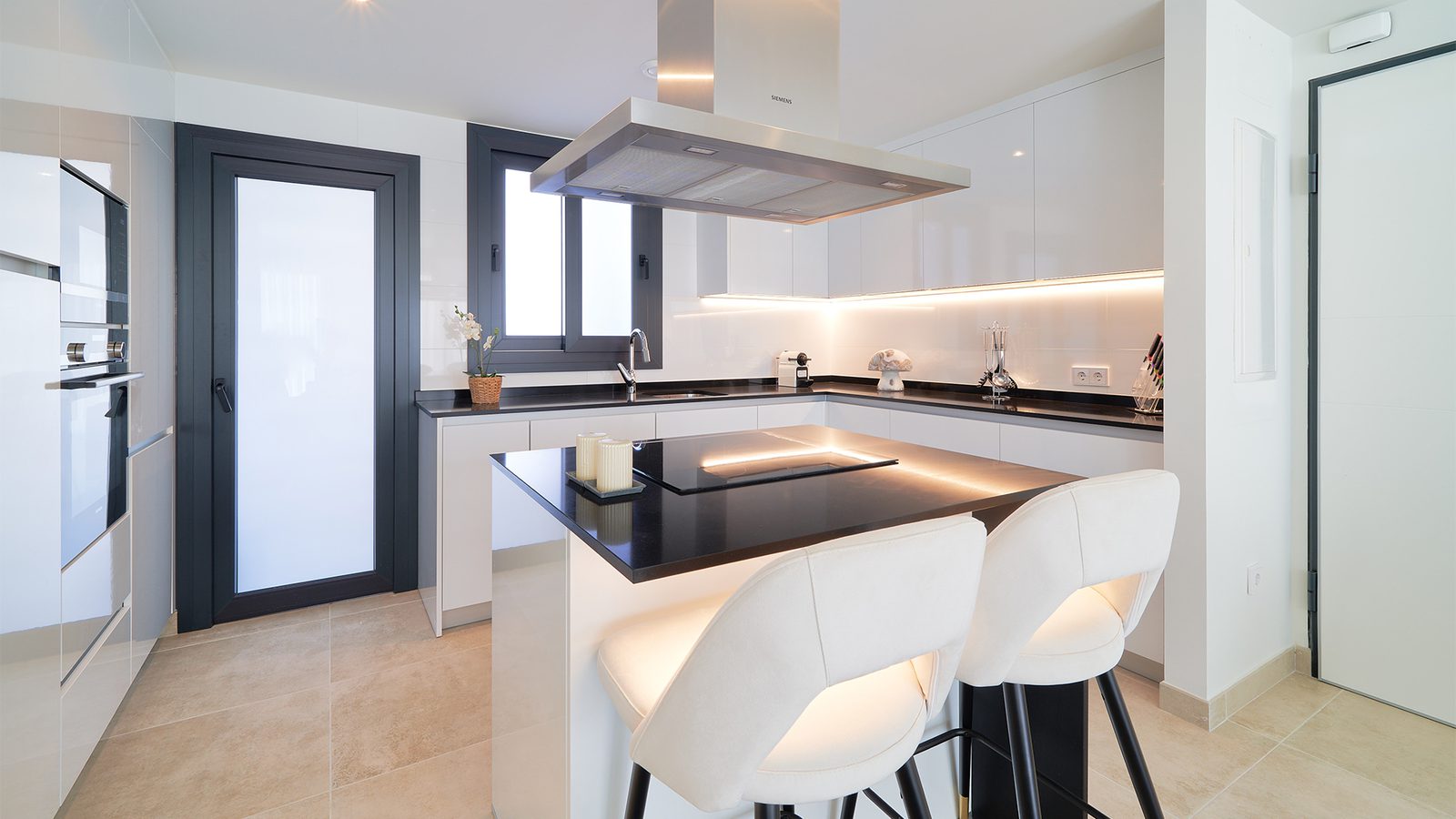 A modern kitchen with a breakfast bar in a 3-bedroom apartment in Estepona - The Estates