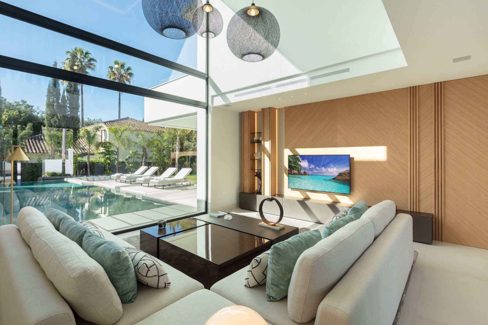 Contemporary living room overlooking the pool and garden of a 5-bedroom villa in Málaga - The Estates