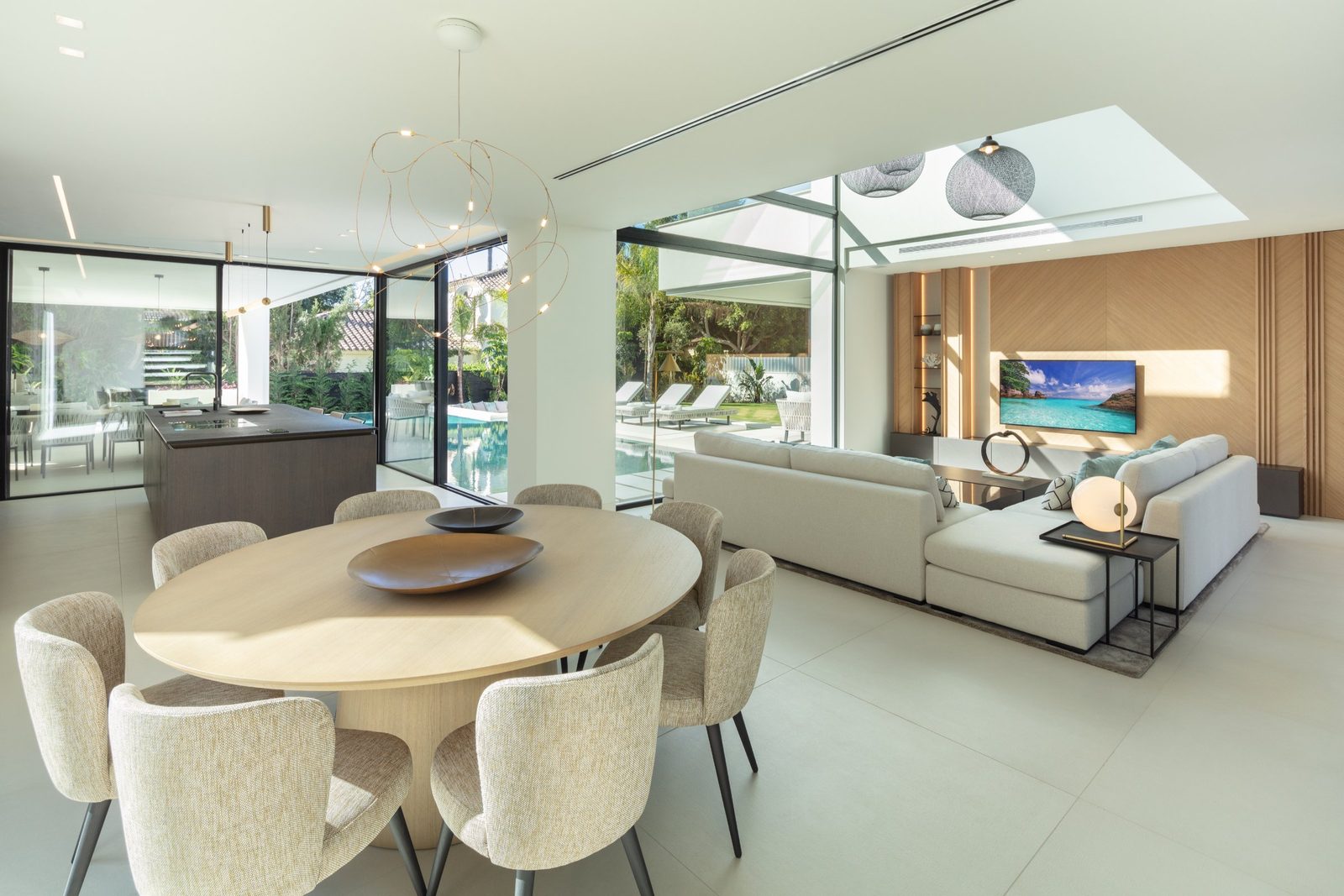Open-plan living, dining and kitchen area overlooking the pool of a 5-bedroom villa in