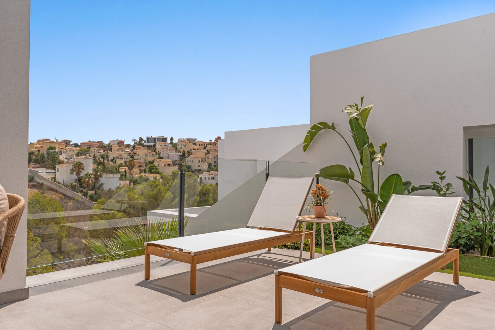 Relaxing lounge chairs and a view of the town from a 3-bedroom apartment in Benitachell - The Estates