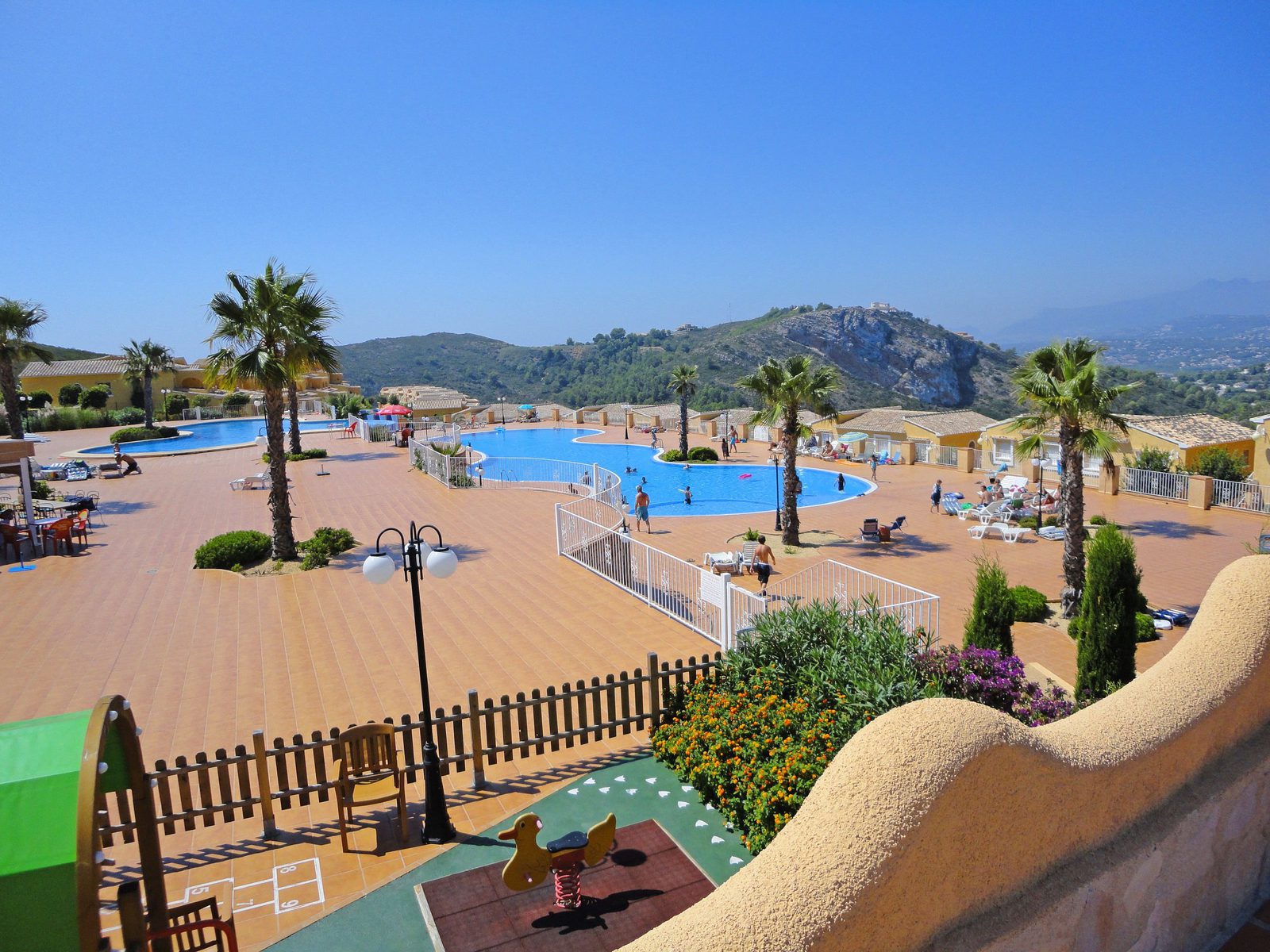 A view of the communal pool and gardens surrounding a 3-bedroom apartment in Benitachell - The Estates