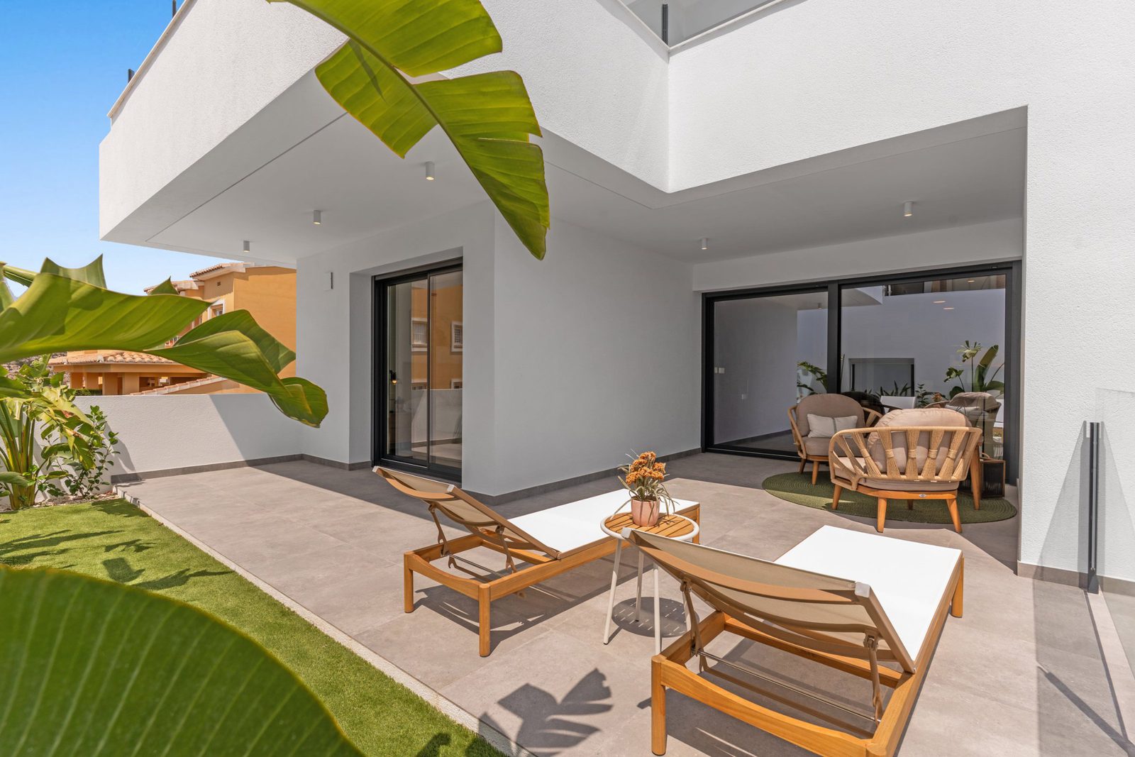 Outdoor terrace with lounge chairs and greenery of a 3-bedroom apartment in Benitachell - The Estates