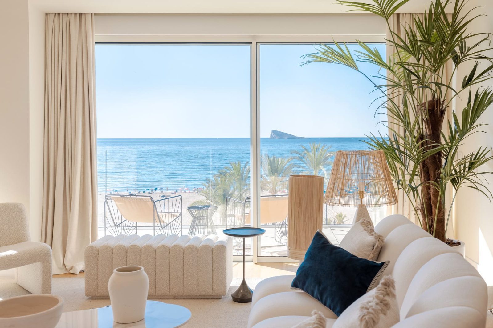 Bright living room with floor-to-ceiling windows overlooking Poniente Beach and the sea in a