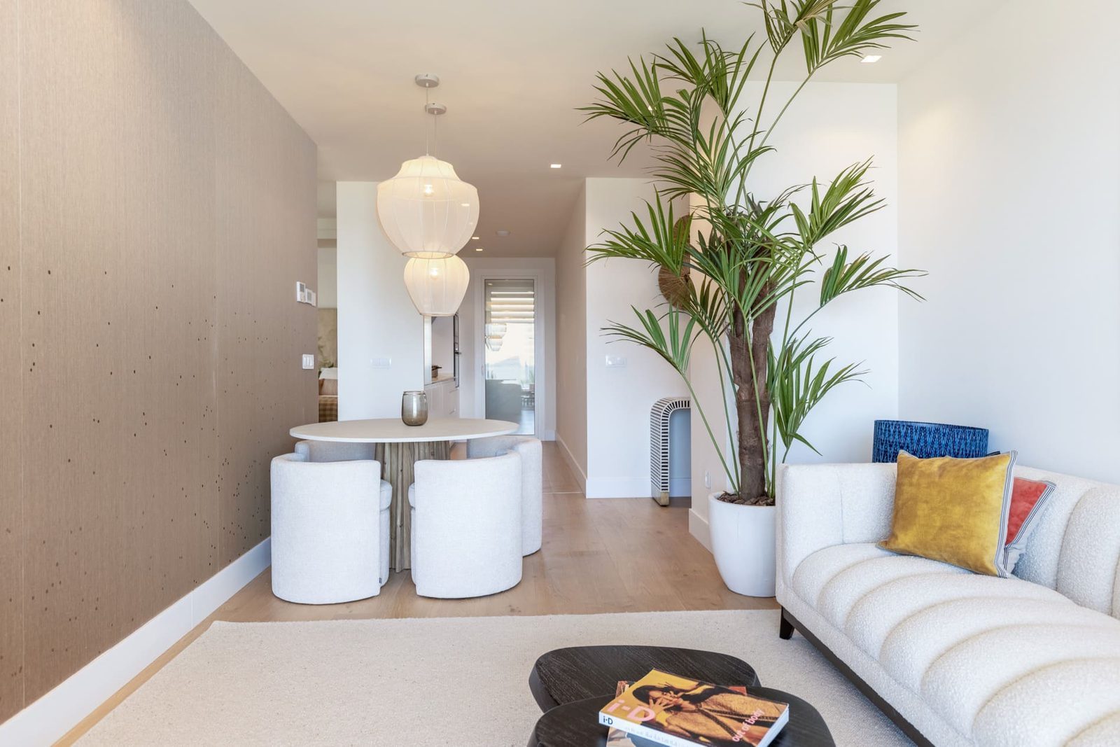 Bright living and dining area with a large potted palm and contemporary furnishings in a 2-bedroom apartment in Benidorm - The Estates